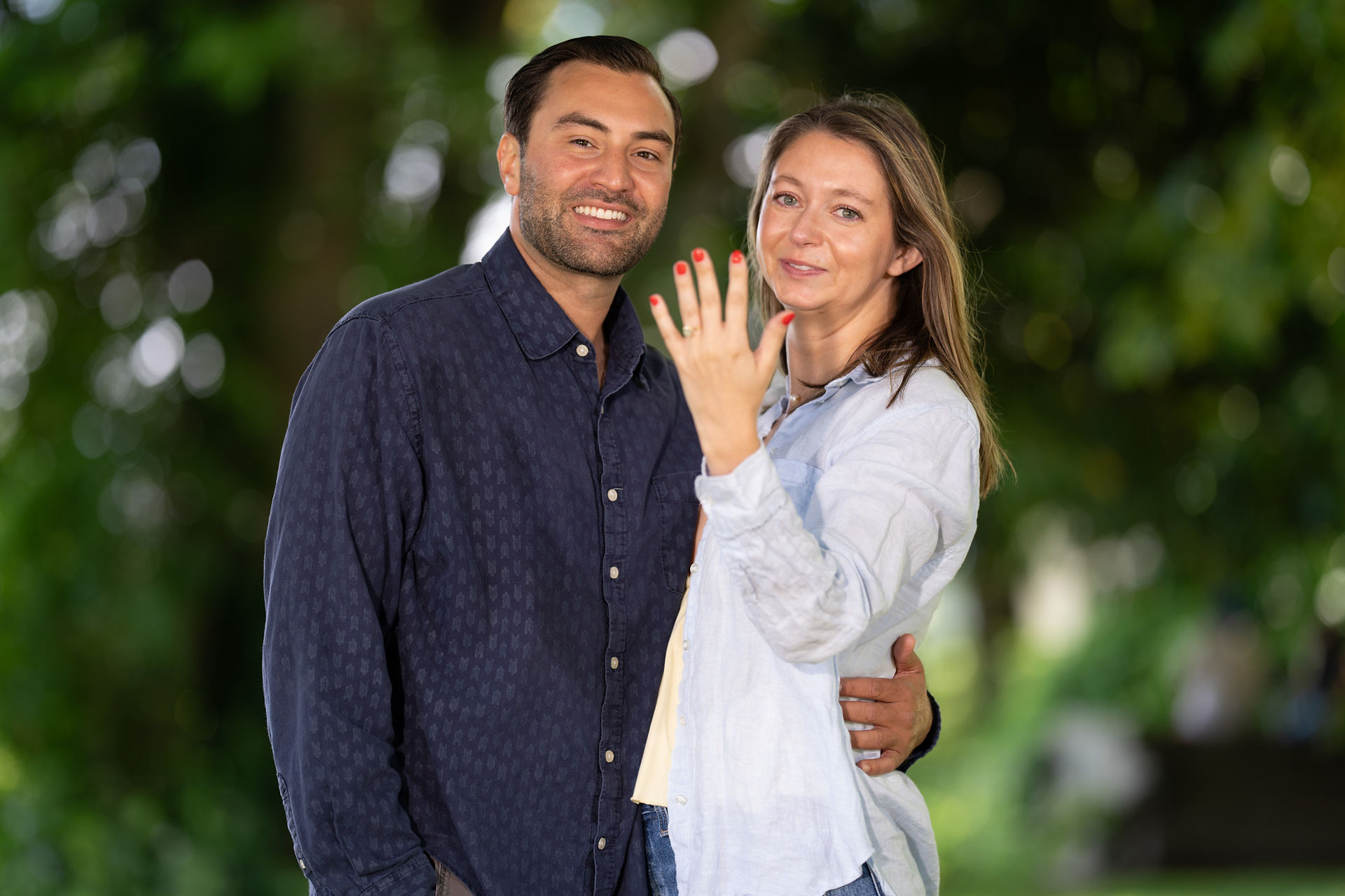 Happy couple, woman showing engagement ring