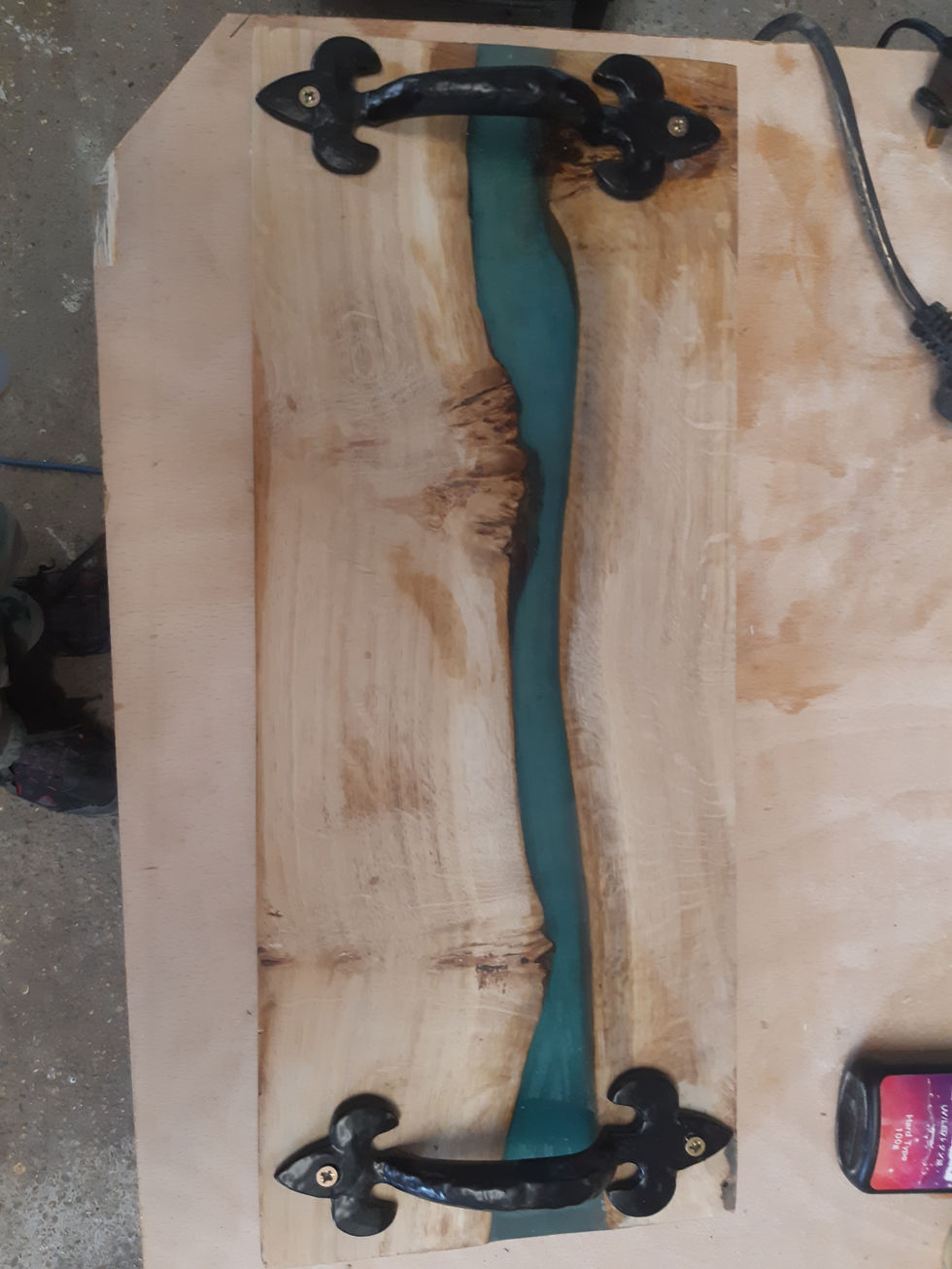 A oak wood tray with a river made of resin running down the centre