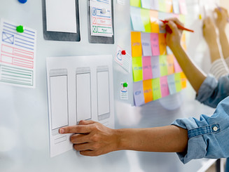 White board with hands and prototyping sheet.