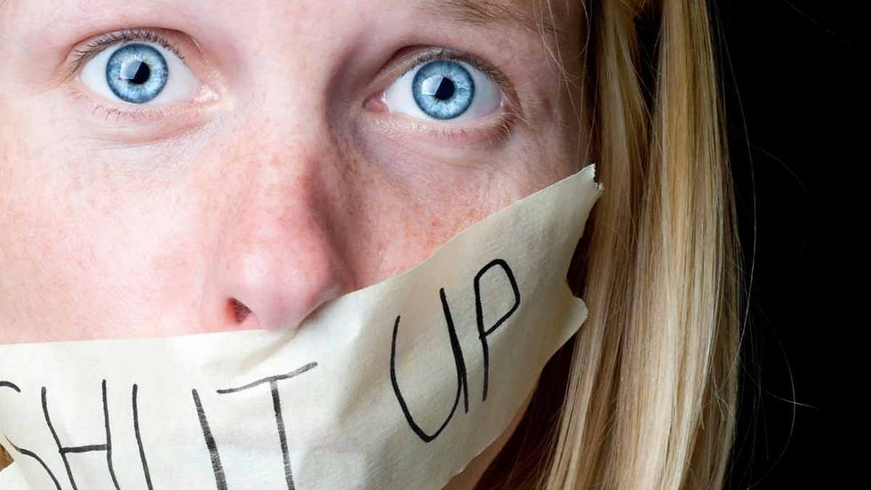 A woman with a piece of tape on her mouth that says, "Shut Up"