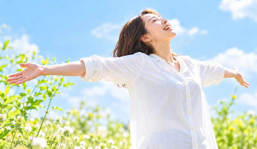 青空の下で自由を感じる女性.jpg