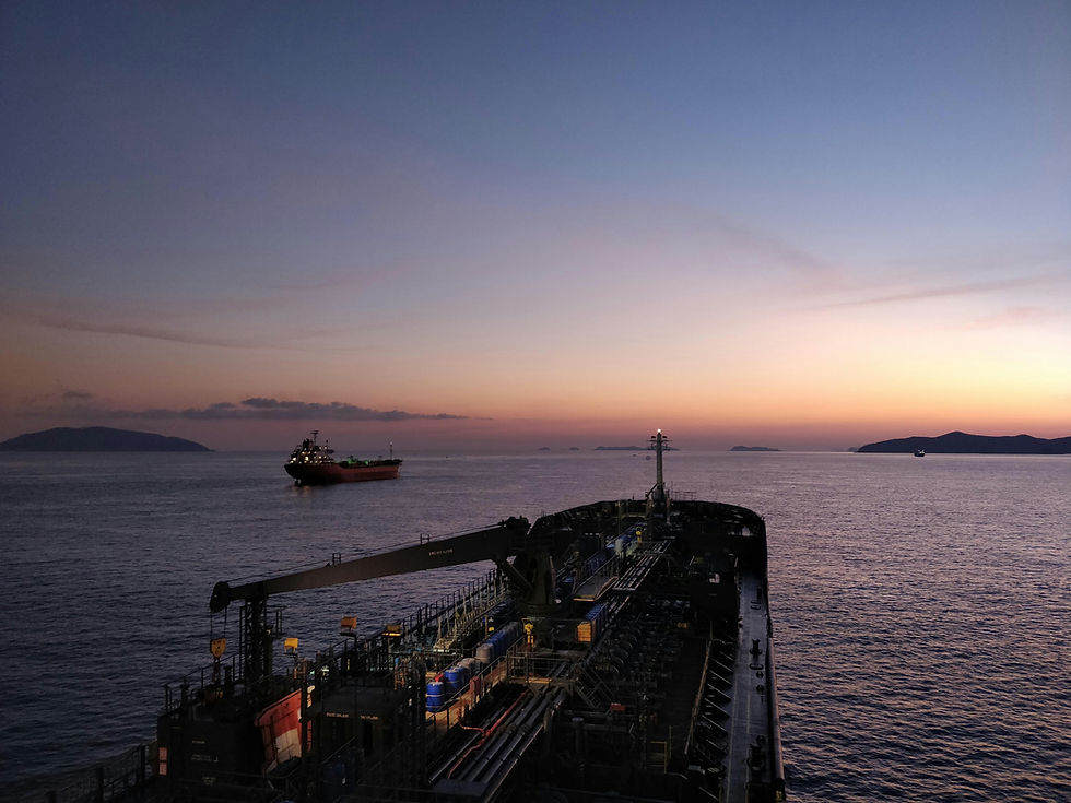 oil tanker navigating the Strait of Hormuz at sunset showing global shipping route