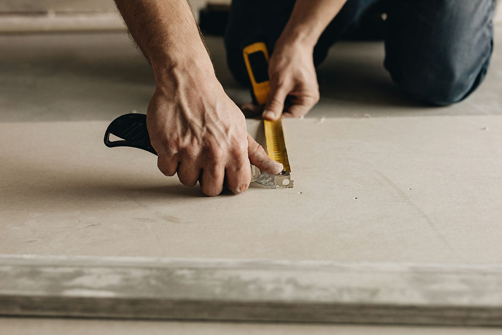Close up of a person's hands as they use a building tool to work on detail on a floor - by Karolina Grabowska for Unsplash