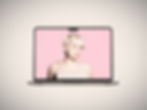 A woman with blond hair has a mac keyboard plugged into her ear.