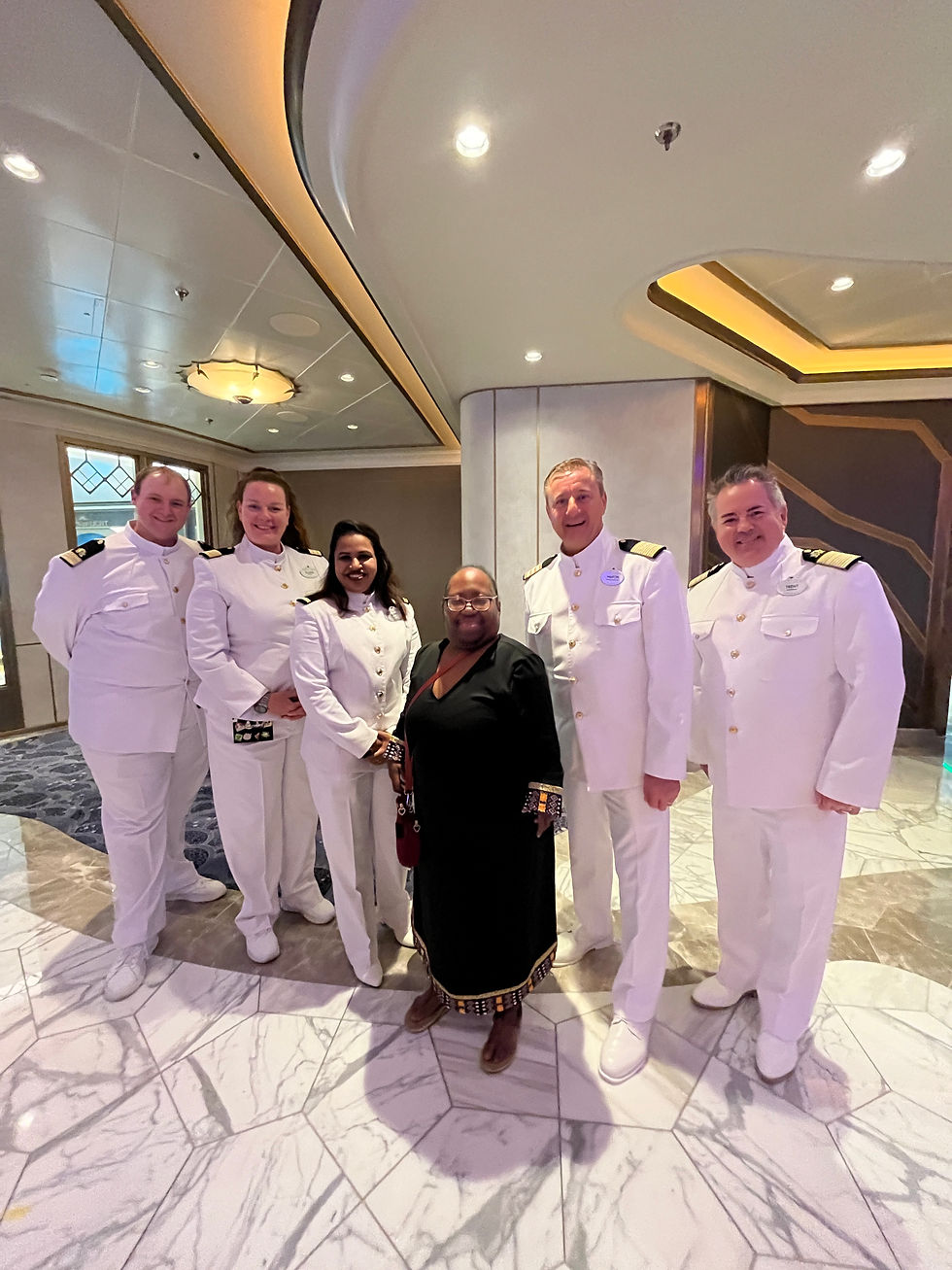 Me with five of the stewards on board the Disney Destiny. ©2026 P Lynne Designs LLC.