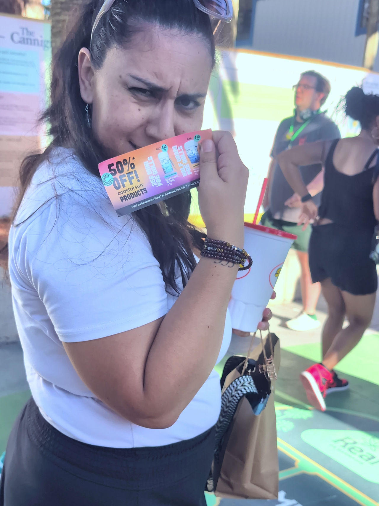 team member holds vouchers with a facial expression that says how good of a deal it is