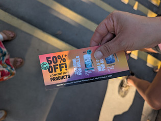 someone's hand with a voucher for 50 percent off Coastal Sun products