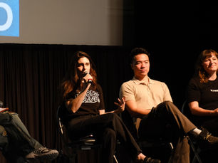 a speaker at Cannaclub event speaks into the microphone next to other panelists