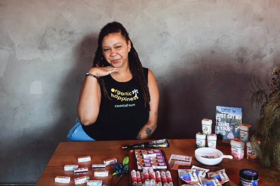 Coastal Sun Brand Ambassador at a table with educational materials, products, and branded merch