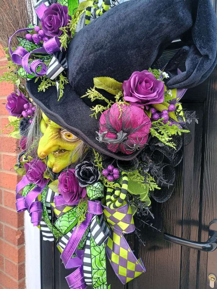 Deep purple and black roses eucalyptus heathers on wicked witch Halloween wreath side view