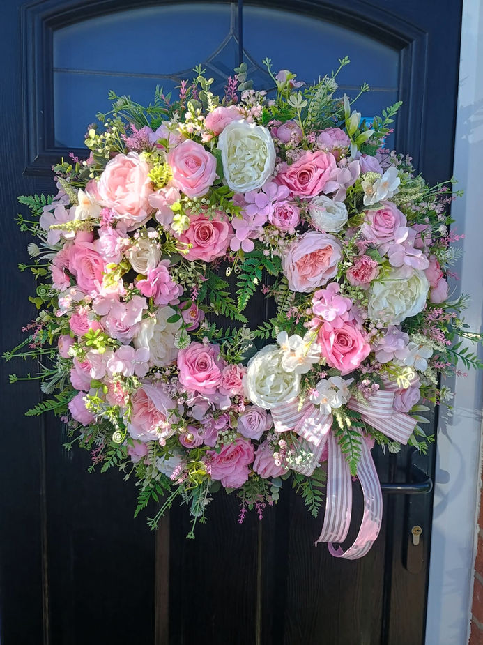 Pink and ivory handmade artificial flower door wreath with realistic roses and foliage, perfect for year‑round decoration.