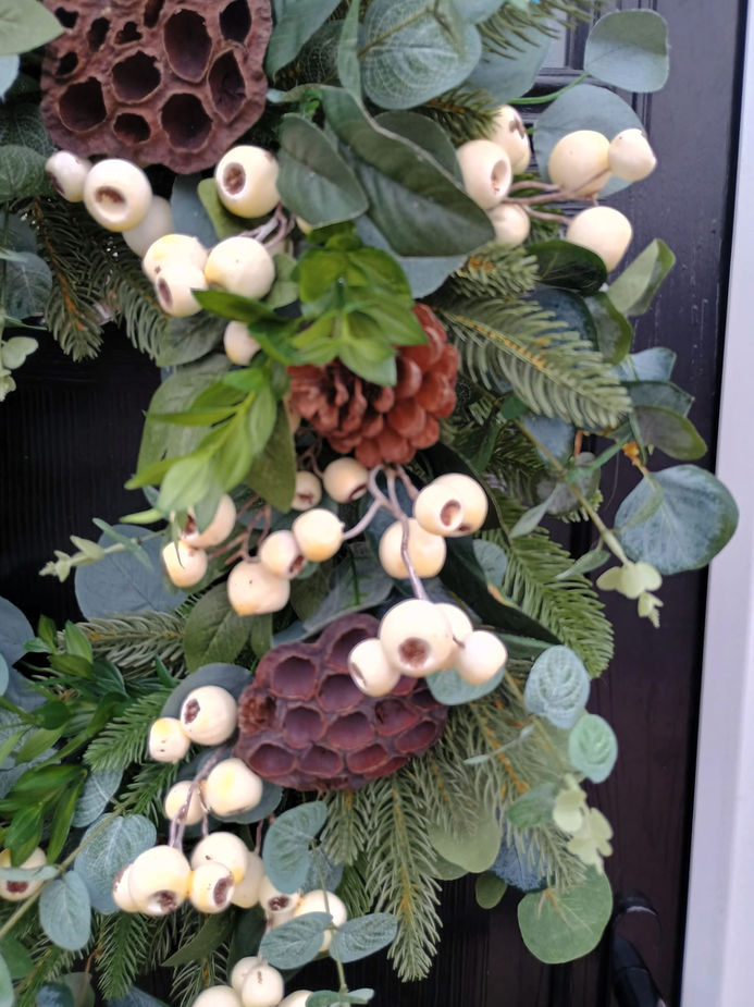Close-up of a festive wreath with white berries and pinecones. White Berry Christmas Door Wreath.