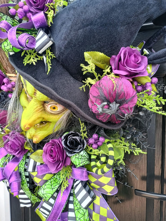 Deep purple and black roses eucalyptus heathers on wicked witch Halloween wreath side view