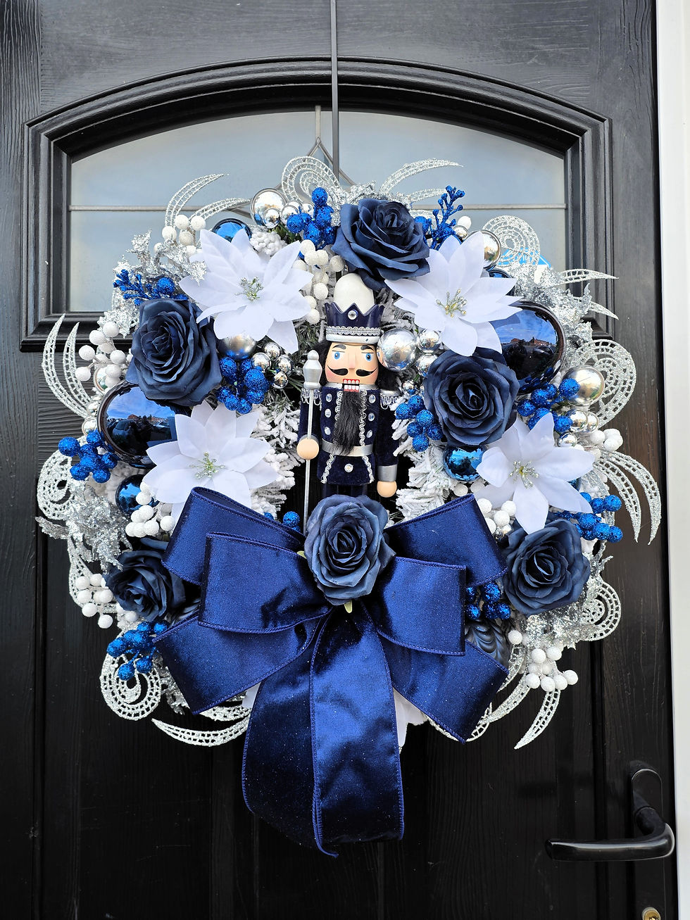 Close up of blue and silver Nutcracker Christmas door wreath on front door