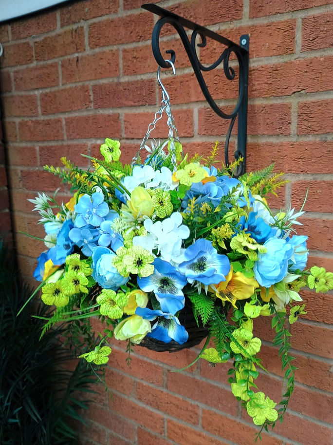Two vibrant blue and yellow flowers are positioned on a brick walkway, creating a charming outdoor display.
