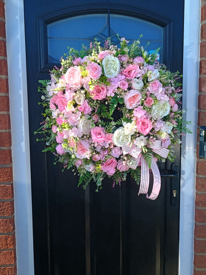 Pink and ivory handmade artificial flower door wreath with realistic roses and foliage, perfect for year‑round decoration.