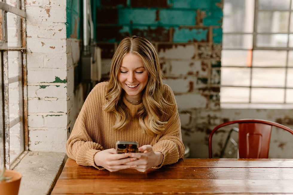 Woman using the free ChatGPT app on her smartphone at a cafe table, where visual ads appear during image generation