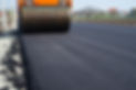 Road roller compacting fresh asphalt during road construction