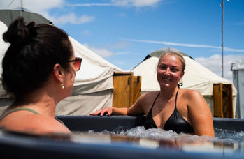 Two guests relaxing in the Revivo Sauna wood-fired hot tub during the British Grand Prix weekend at Silverstone.