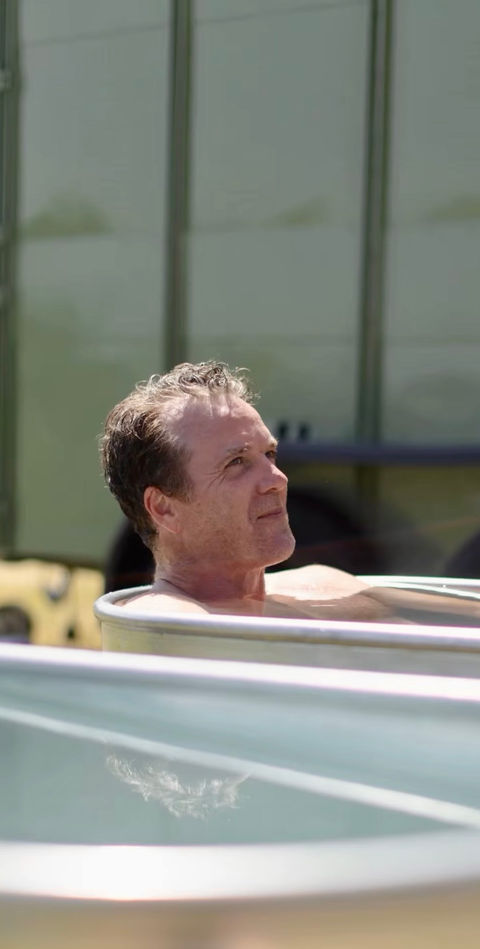 Guest relaxing in a cold plunge during Revivo Sauna's Father's Day wellness event at Saffron Grange Vineyard, Saffron Walden.