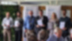 An image of IoA award recipients receiving awards from the IoA. All recipients are wearing smart clothing, and are stood in a room with a number of audience members sat at the bottom of the frame. Angela is stood 2nd from the right, Peter is stood 3rd from the right, and Alistair is stood 4th from the right.
