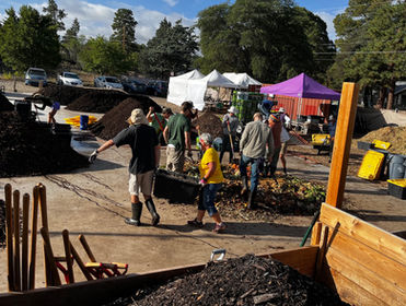 Several people at work with mounds of dirt, tools, and tents.