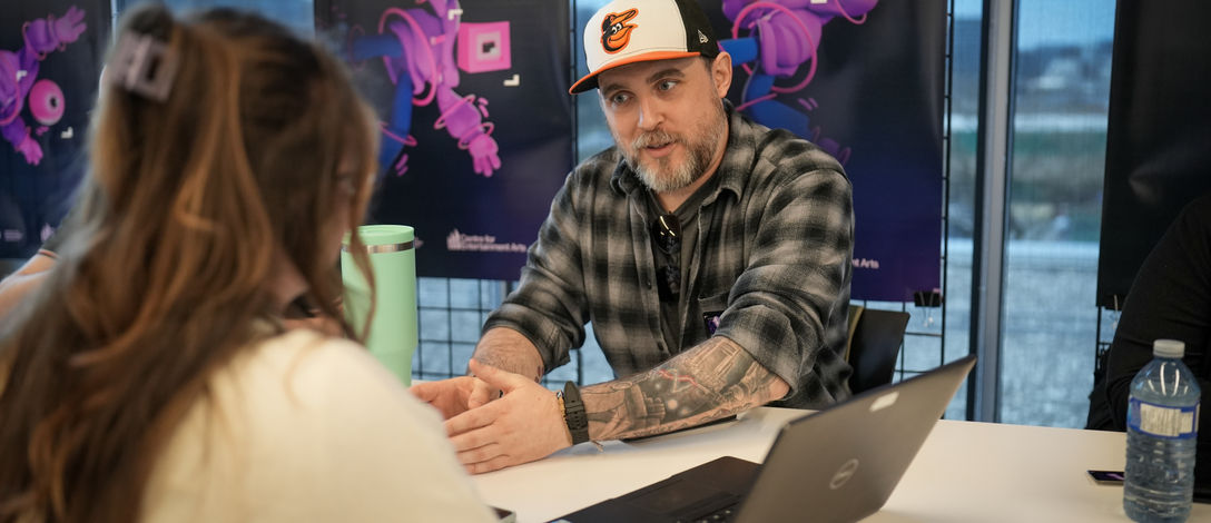 A photo of an industry professional talking to a student.