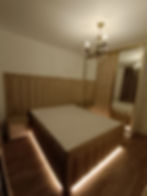 Pat dublu tapitat elegant cu lumina sub pat ambientala cu banda LED. Tablia este lata si are detalii aurii din tinte.
