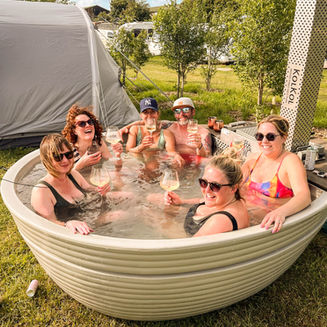 Guests of Yellow Submarine Glamping sitting in the Hot Tub at Petruth Paddocks in Somerset.