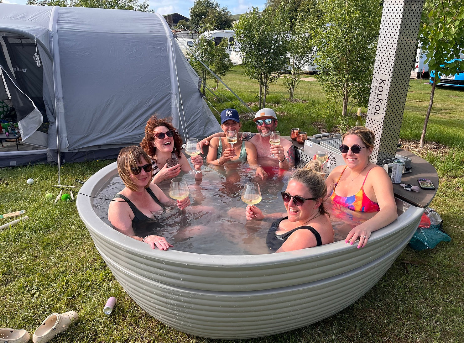 People sitting in a Hot Tub at American School Bus Glamping in Somerset.