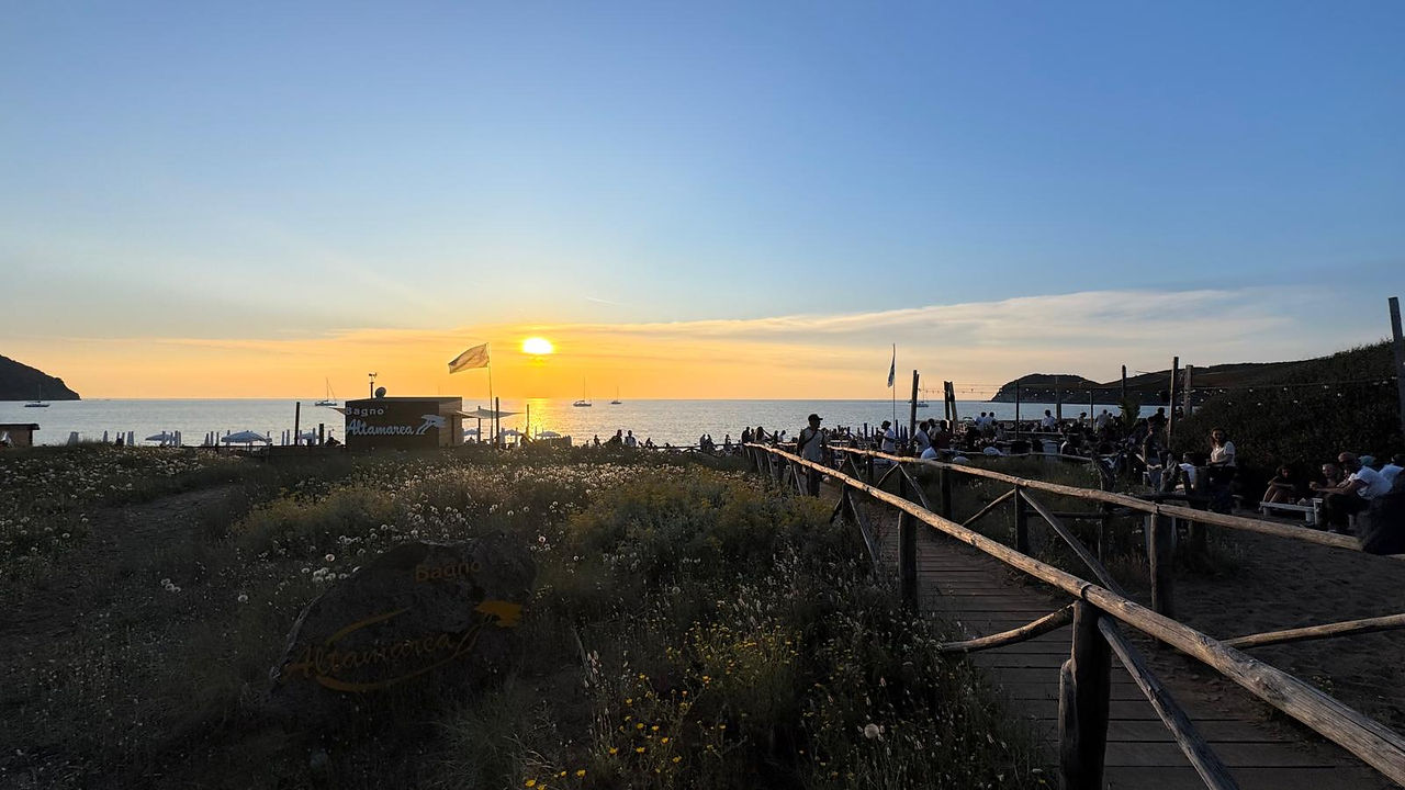 Sonnenuntergangsparty am Strand von Baratti in der Toskana während des Sonnenuntergangs