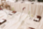 wedding table setting with bud vases and burgundy napkins