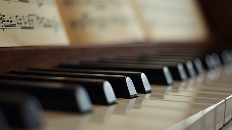Close-up view of piano keys with sheet music in the background
