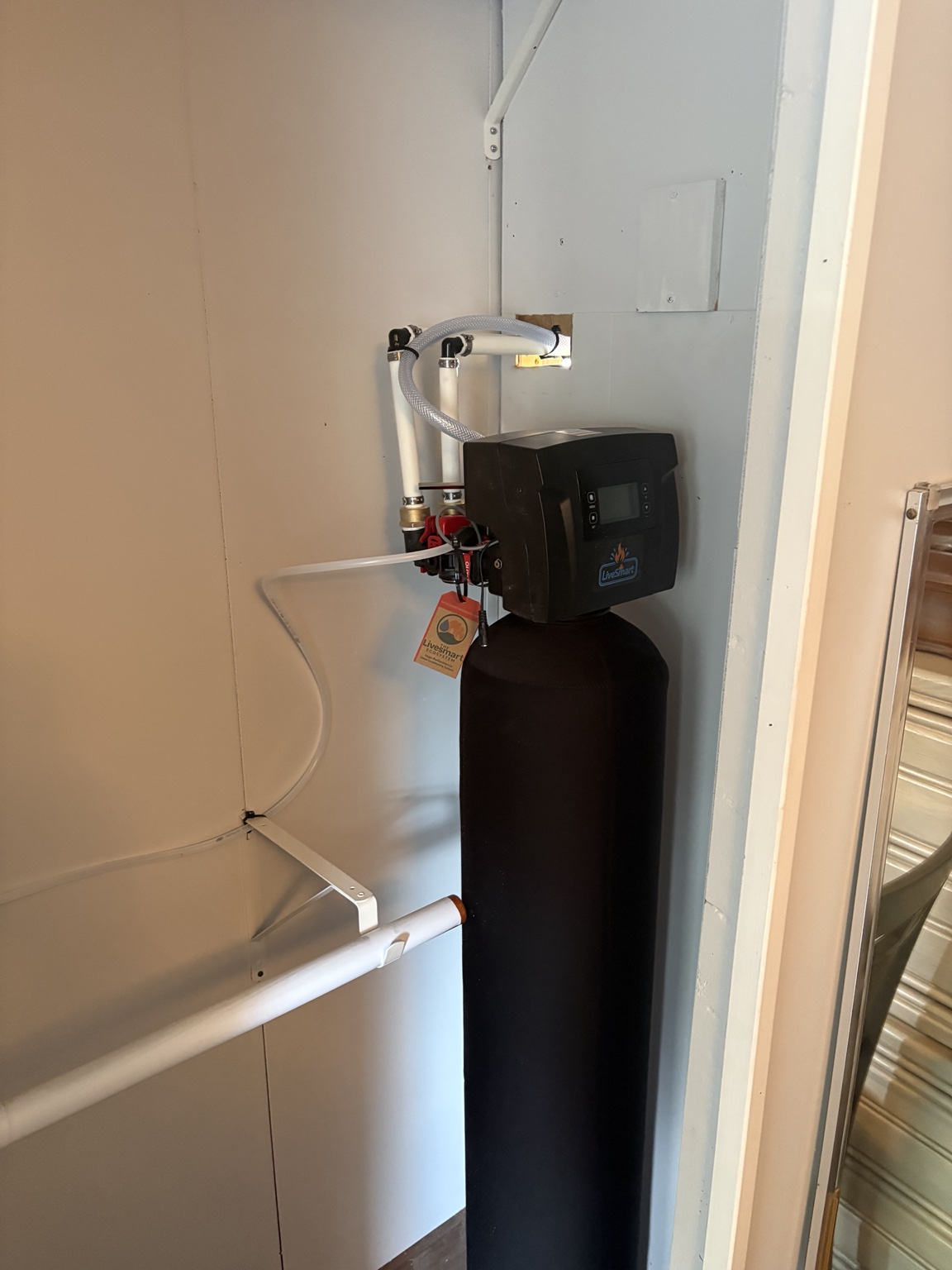 LiveSmart water-treatment equipment installed in a narrow closet