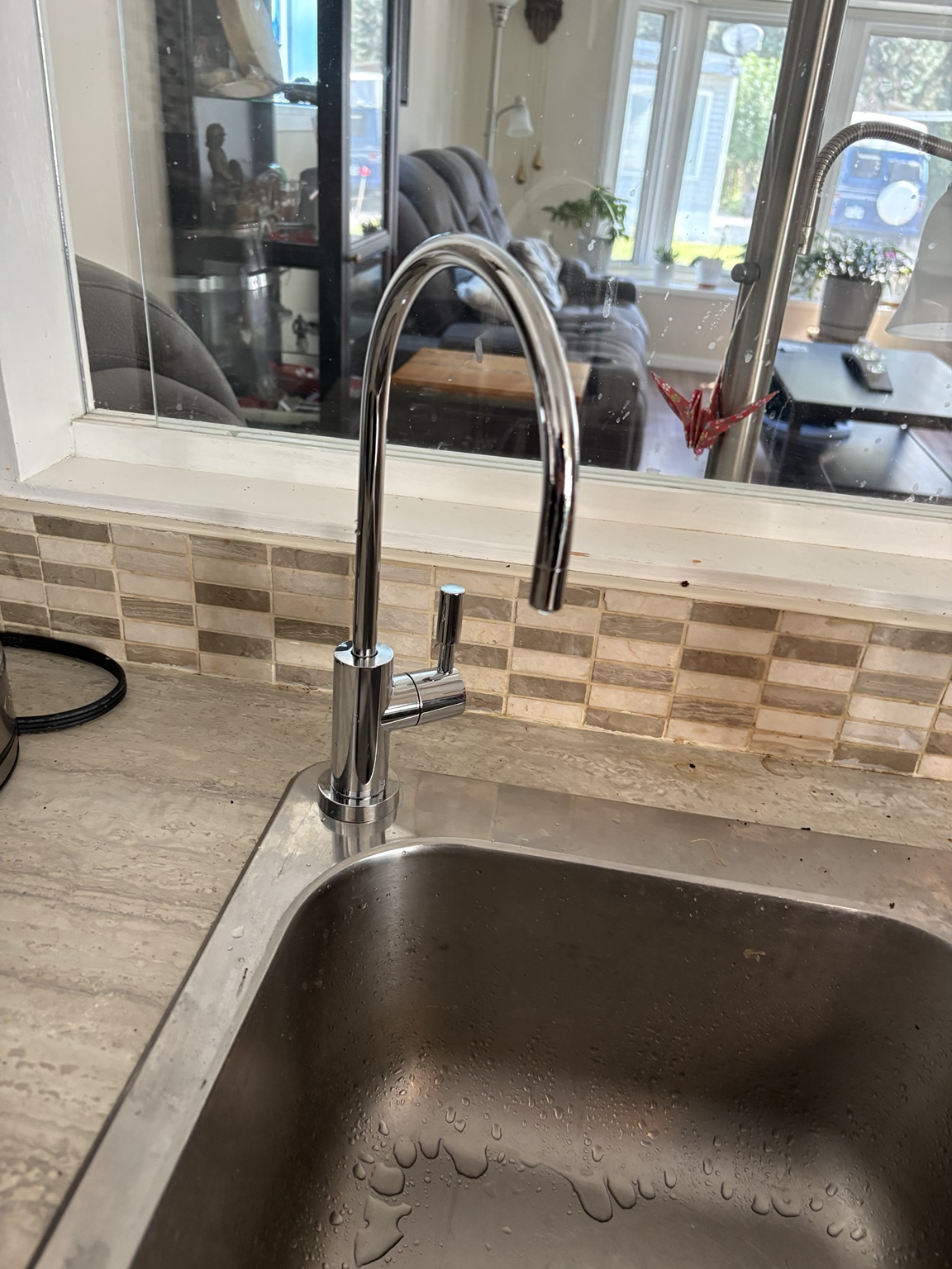 Chrome drinking-water faucet beside a kitchen sink