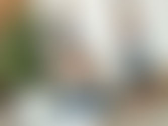 Parent assis sur un canapé avec deux enfants en arrière-plan, illustrant le quotidien familial.