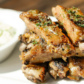 The image features a plate of food that includes roasted chicken, likely prepared with Jamaican jerk spice and teriyaki marinade. The dish represents a blend of cooking techniques such as roasting and frying, showcasing an appetizing combination of flavors typical in various cuisines. This indoor meal is perfect for those looking to enjoy a flavorful chicken dish.