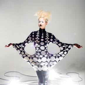 The image features a mannequin dressed in a stylish outfit. It represents a fashion design concept and is likely set indoors. The doll-like figure showcases clothing and footwear, capturing the essence of fashion in a creative manner.