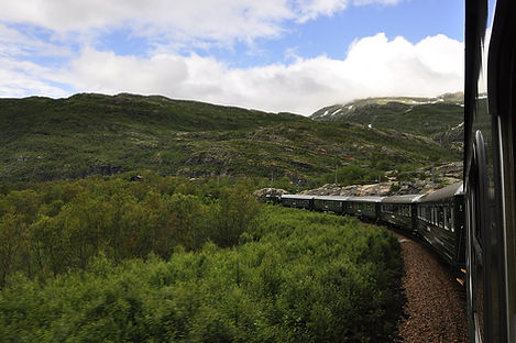 a Flam Railway train traveling through the mountains of Norway, a destination or experience featured on the Norwegian Fjords Escape with Northern Lights tour