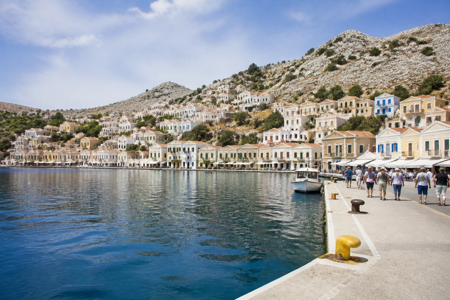 Representative cruise port destination view: Symi, Greece; passenger waterfront and harbor water, not an exact landmark photograph.