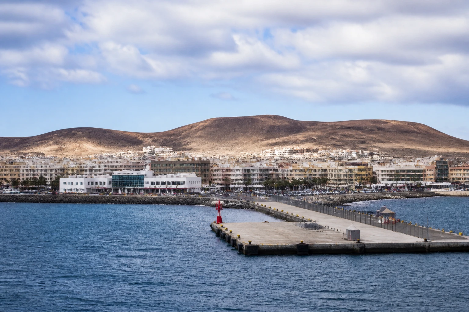 Representative cruise port destination view: Puerto del Rosario, Spain; passenger waterfront and harbor water, not an exact landmark photograph.