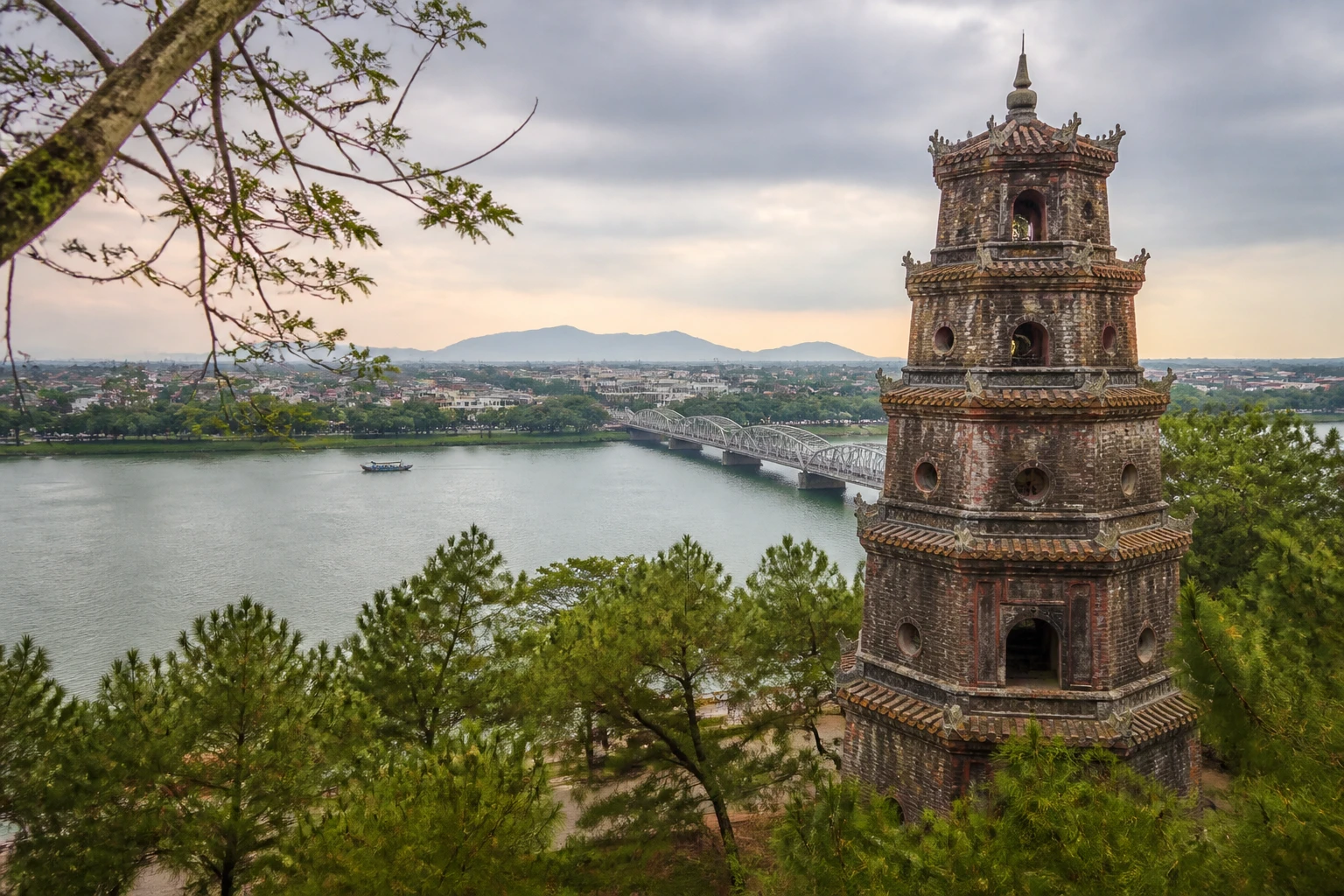 Representative river destination view of Hue in Vietnam, with inland water, regional terrain, vegetation, and natural light; not an exact landmark photograph.