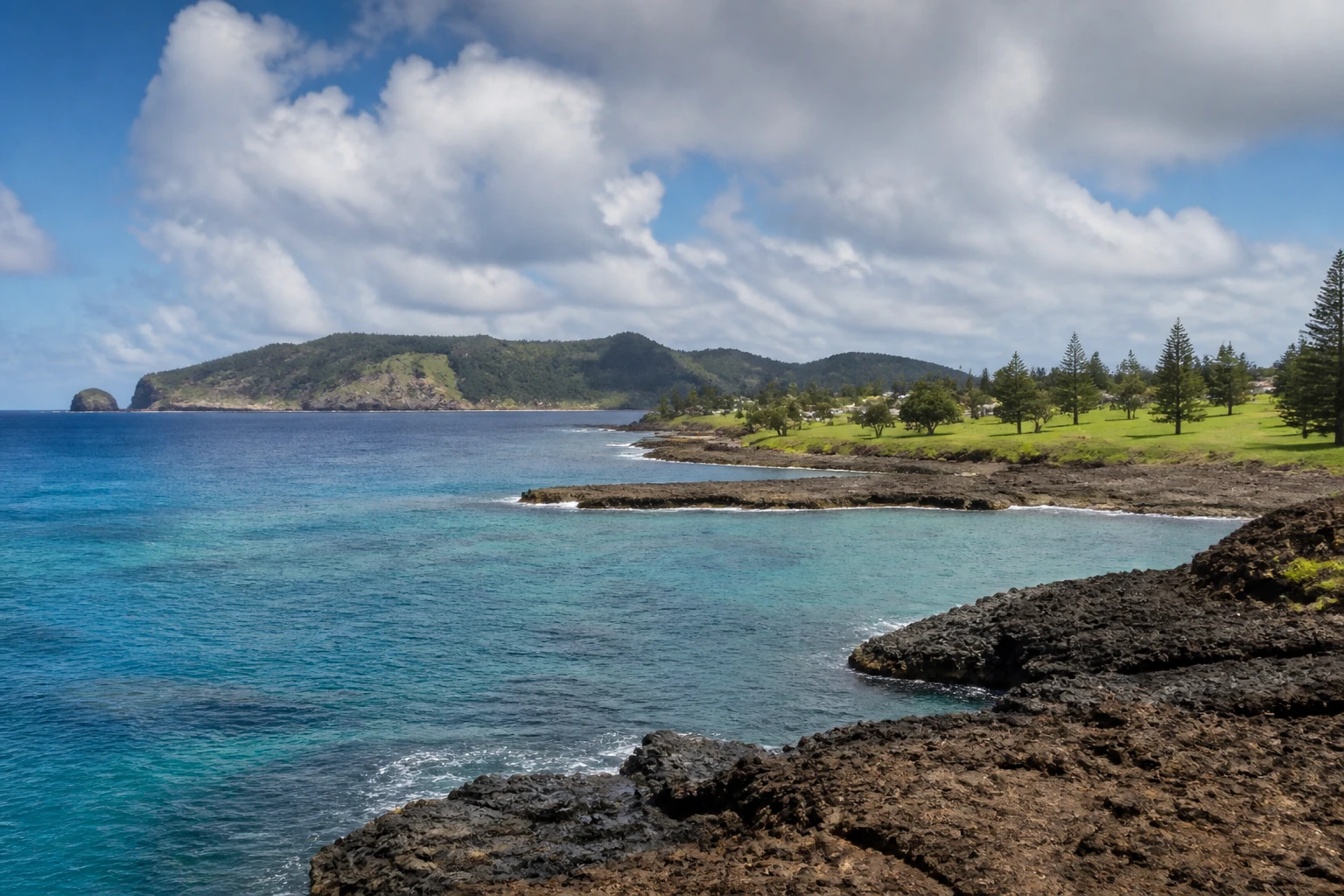 Representative cruise port destination view: Norfolk Island, Australia; coastline and regional vegetation, not an exact landmark photograph.