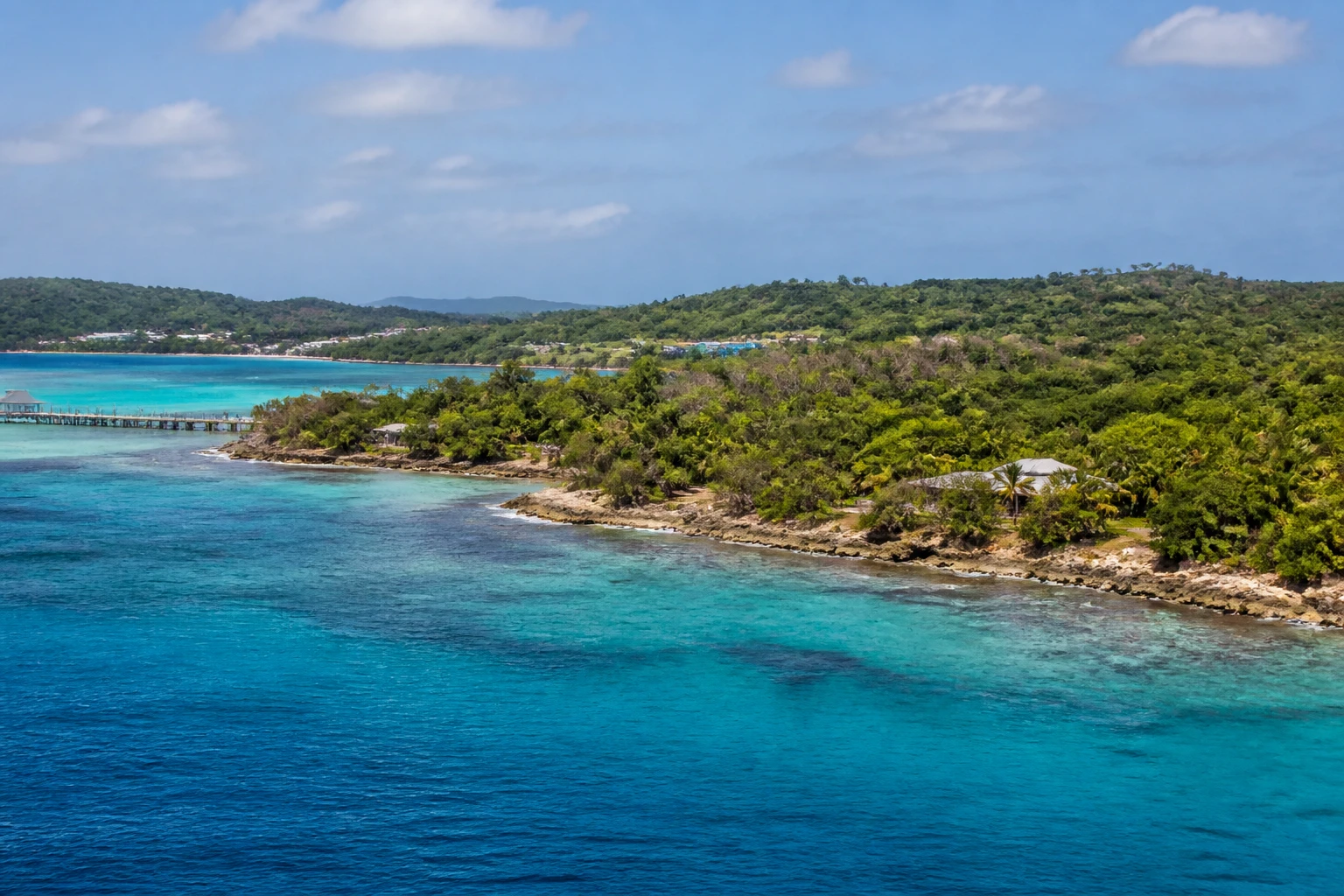 Representative island destination view: Roatan, Honduras; coastline and regional vegetation, not an exact landmark photograph.