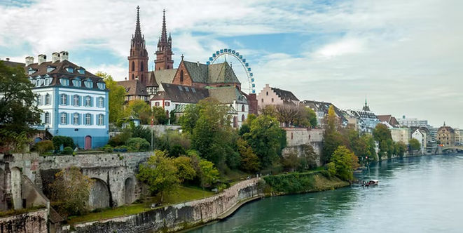 Basel Minster and historic riverside buildings overlooking the Rhine River in Basel, Switzerland.