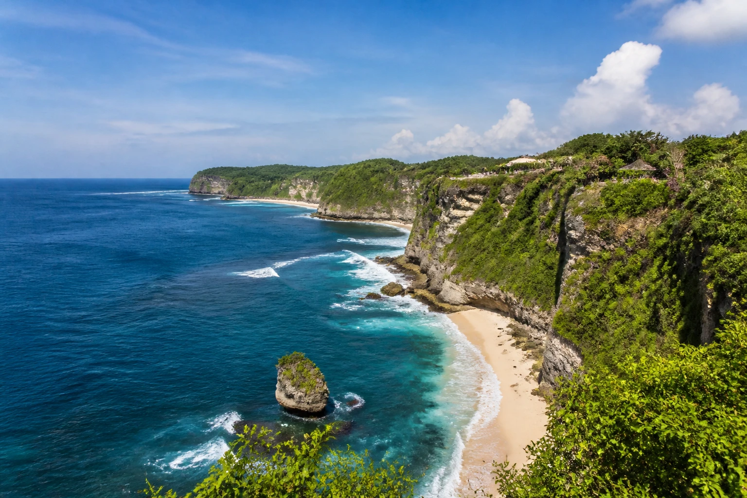 Representative island destination view: Bali, Indonesia; coastline and regional vegetation, not an exact landmark photograph.
