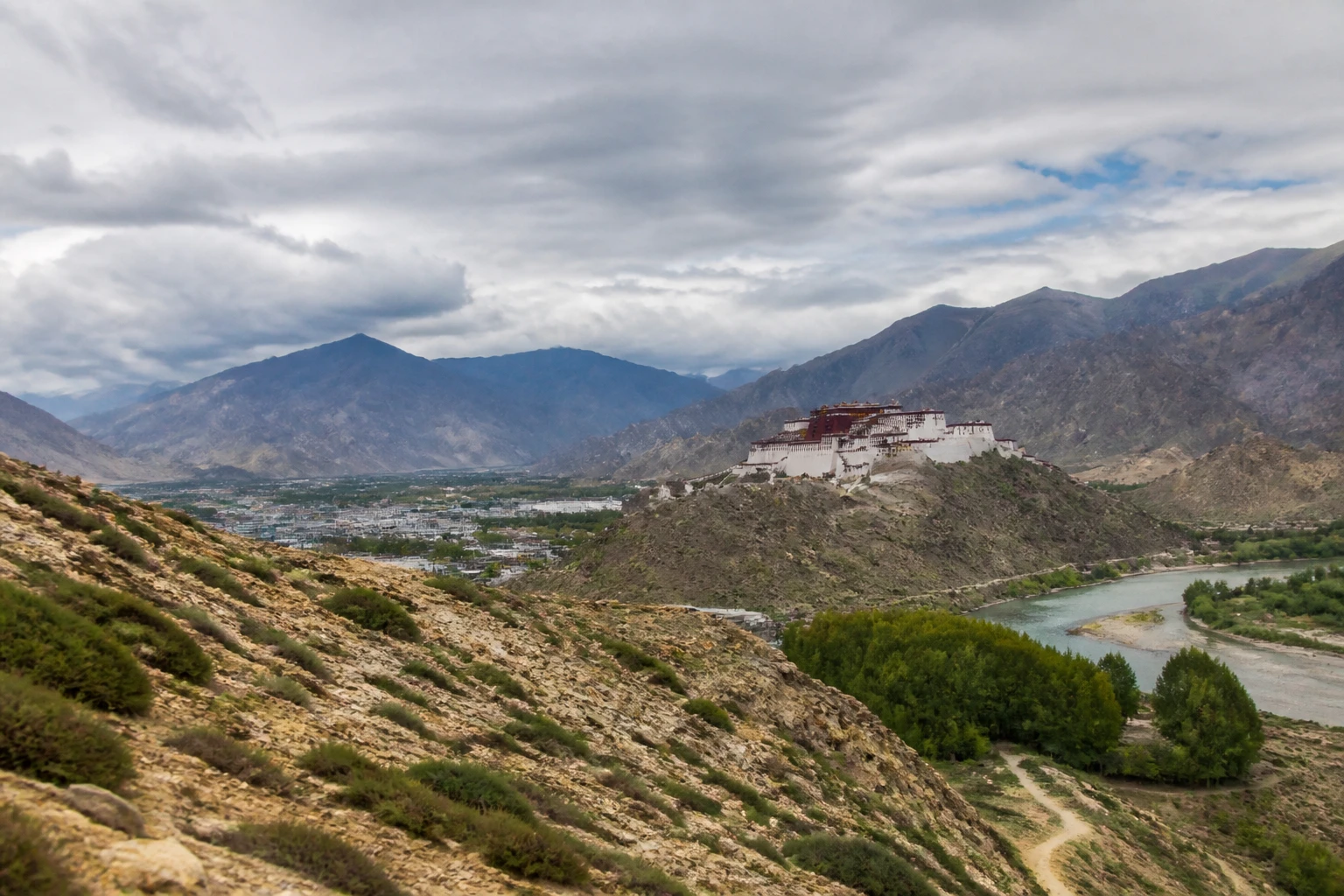 Representative mountain destination view: Lhasa and Tibet, China; mountain or canyon terrain and regional vegetation, not an exact landmark photograph.