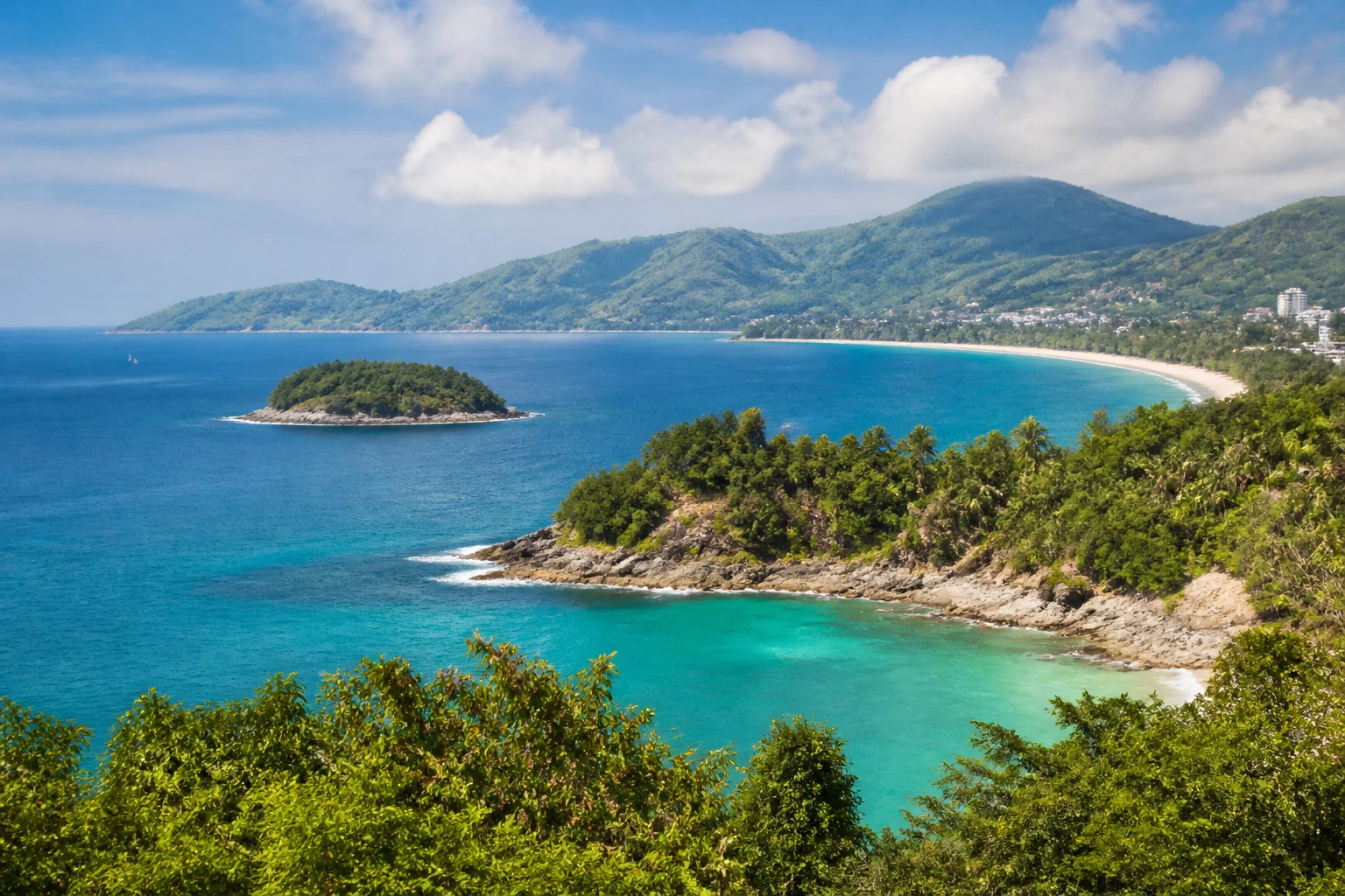Representative island destination view: Phuket, Thailand; coastline and regional vegetation, not an exact landmark photograph.