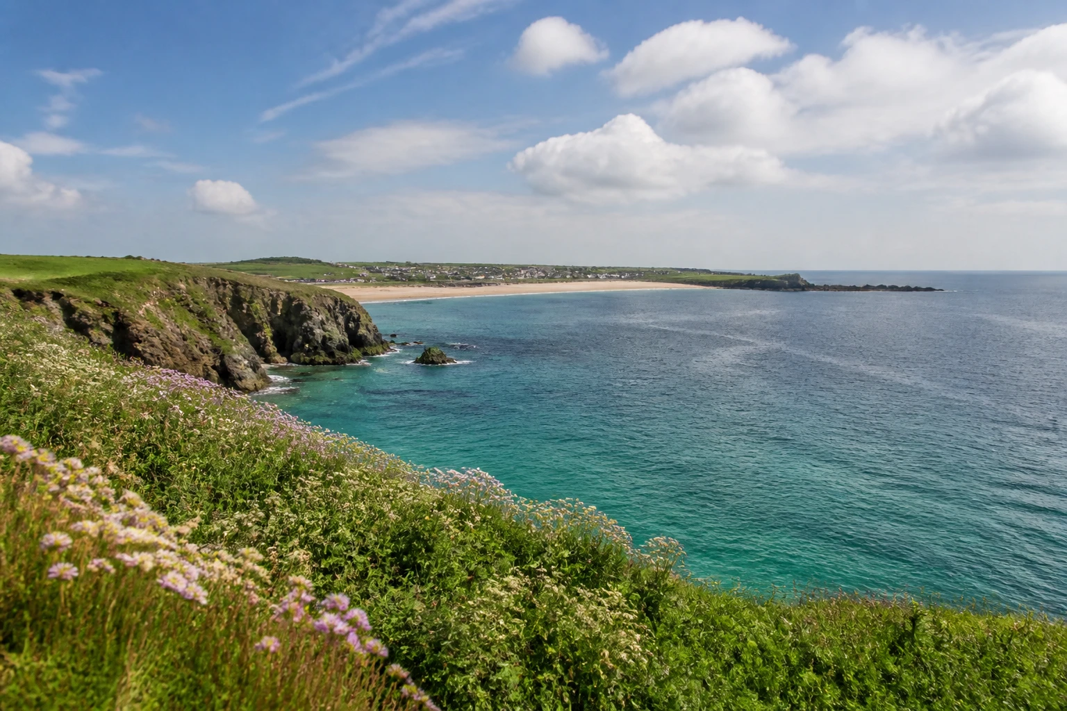 Representative coastal destination view: Cornwall, United Kingdom; coastline and regional vegetation, not an exact landmark photograph.