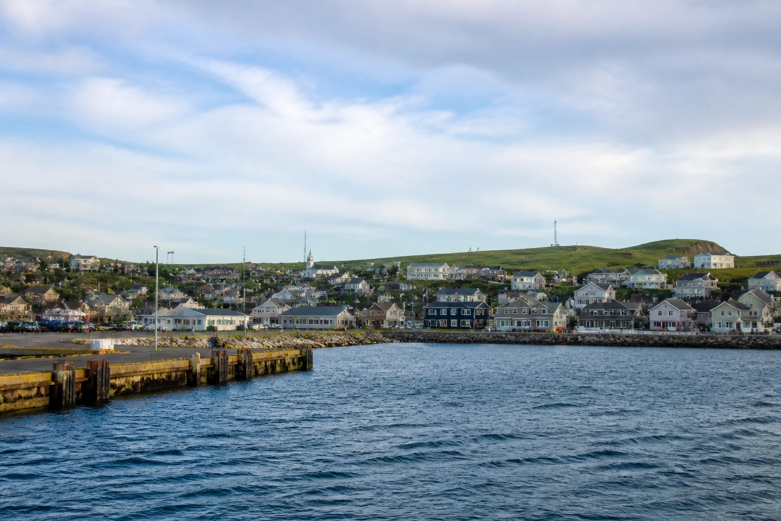 Representative cruise port destination view: Cap-aux-Meules, Canada; passenger waterfront and harbor water, not an exact landmark photograph.